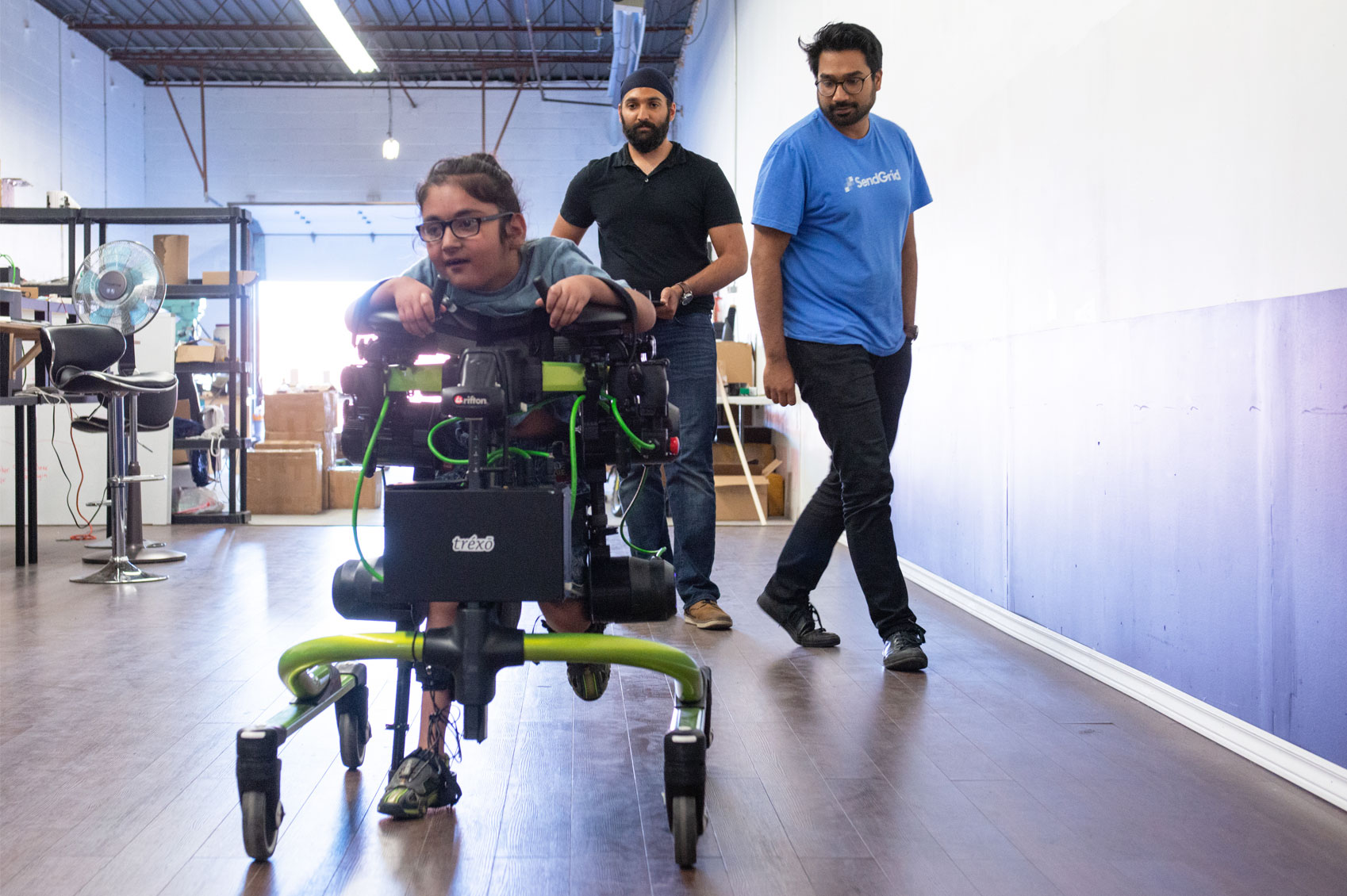 A child and two men conduct testing on a develop innovation.